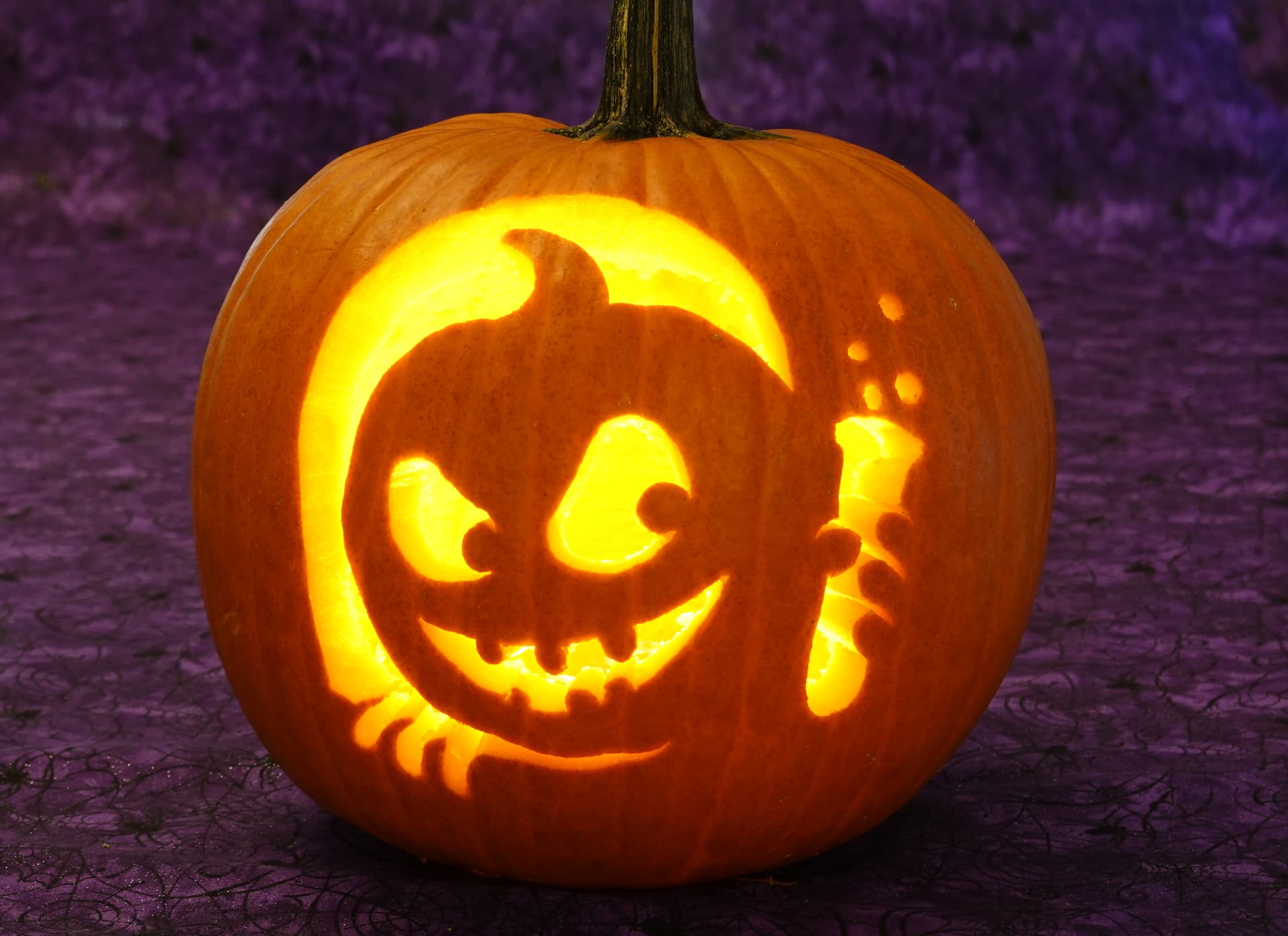 The same mad scientist jack-o'-lantern glowing from inside with a battery-operated light