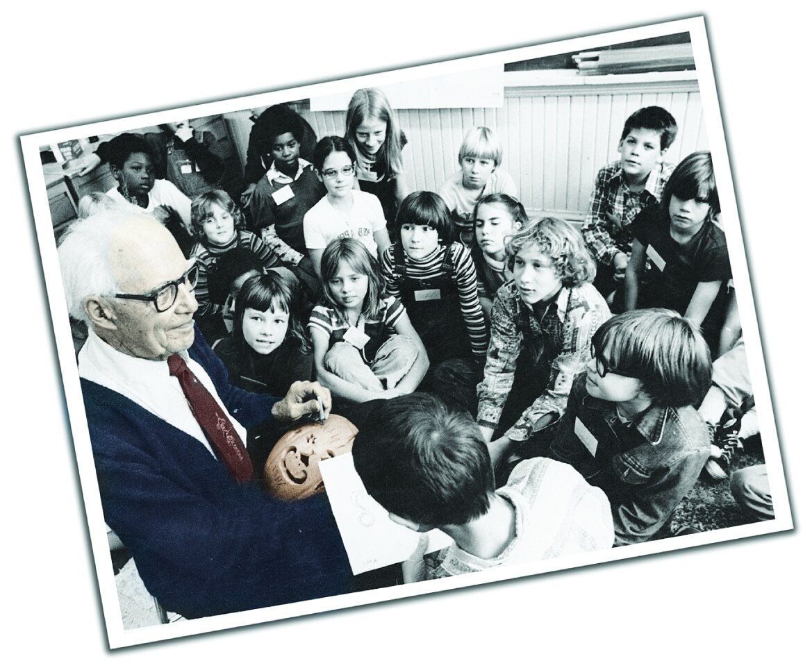 Paul Bardeen, the founder of Pumpkin Masters, demonstrating pumpkin carving to a group of children